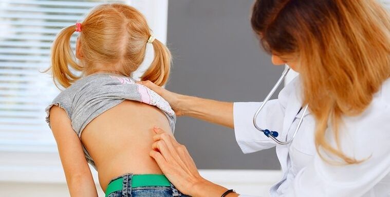 doctor examining a child's back for low back pain